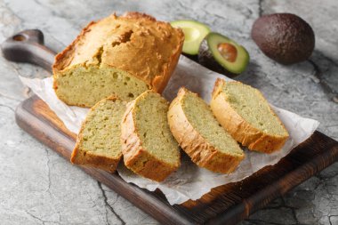 Glütensiz vejetaryen avokado ekmeği dilimlenmiş mi? Somun somunu masadaki tahtaya yakın tut. Yatay