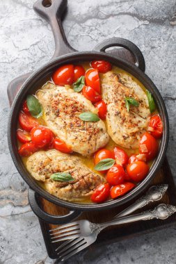 Domates soslu tavuk göğsü soğan, sarımsak, tavuk çorbası olgun domatesler ve masanın üstündeki tavaya yakın taze fesleğen. Yukarıdan dikey üst görünüm