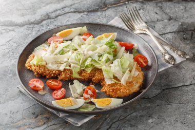 Kızarmış tavuk eti, yumurta, parmesan, buzdağı marulu ve domatesli salata, masanın üstünde. yatay