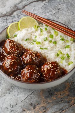 Yapışkan ballı sriracha köfteleri ve masanın üzerindeki kaseye yakın pilav. Dikey