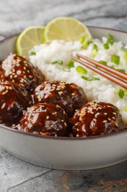 Asya Balı Sriracha Köfteleri. Masanın üzerindeki kaseye yakın pilav. Dikey