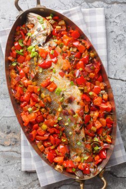 Bütün deniz levreği biber, soğan, domates, sarımsak ve kereviz ile pişirilmiş. Yukarıdan dikey üst görünüm