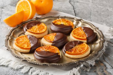 Karamelli meyveli çıtır aromalı turuncu kurabiyeler ve yakın plan çikolatalı jöleler masanın üstünde. Yatay