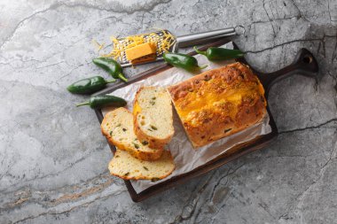 Ev yapımı jalapeno peynirli ekmek dilimi mi? Masadaki kesme tahtasının üzerinde kalın dilimler halinde. Yukarıdan yatay üst görünüm