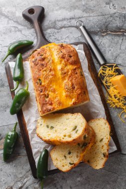 Jalapeno biberli ev yapımı ekmek ve masadaki tahta tahtaya yakın plan çedar peyniri. Yukarıdan dikey üst görünüm