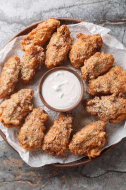 Peynirli, soğanlı ve masanın üstündeki tabağa yakın sarımsaklı tavuk kanadı. Yukarıdan dikey üst görünüm