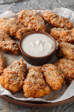 Kore Bburinkle Chicken, peynirli, soğanlı ve masanın üzerindeki tabakta yakın plan sarımsaklı tavuktur. Dikey