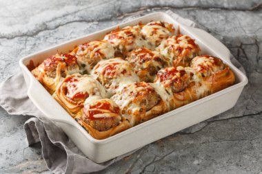 Köftelerle dolu, domates soslu ve peynirle kaplanmış yemek rulolarından yapılmış sıcak sandviçler. yatay