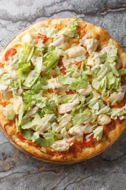 Beyaz soslu Sezar pizzası, peynir, domates, tavuk göğsü ve marul yakın plan masa üzerinde. Yukarıdan dikey üst görünüm