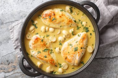 Lezzetli tavuk Diane kremalı brendi sosu ve masanın üstündeki tavaya yakın duran mantarlar. Yukarıdan yatay üst görünüm