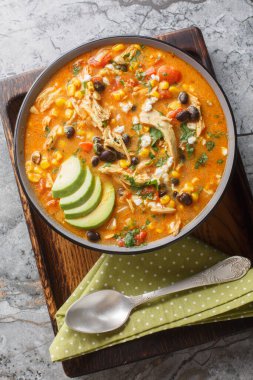 Tavuk Enchilada Çorbası kremalı, kalın, çok rahatlatıcı ve masanın üzerindeki tabağa çok yakın. Yukarıdan dikey üst görünüm