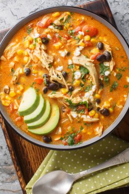 Meksika kremalı enchilada çorbası. İçi tavuk, mısır ve fasulye dolu. Masanın üstünde yakın plan. Yukarıdan dikey üst görünüm