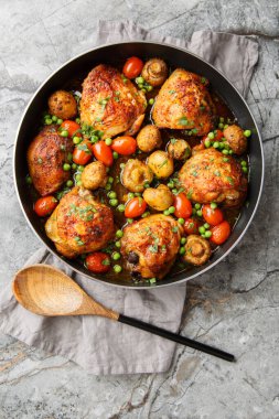 Bal aromalı mantarlı tavuk butları, yeşil bezelyeler, vişneli domatesler ve masada yakın plan otlar. Yukarıdan dikey üst görünüm