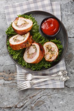 Pastırma, soğan ve mantarlı fırınlanmış hindi göğsü, masada yakın plan domates sosuyla servis ediliyor. Yukarıdan dikey üst görünüm