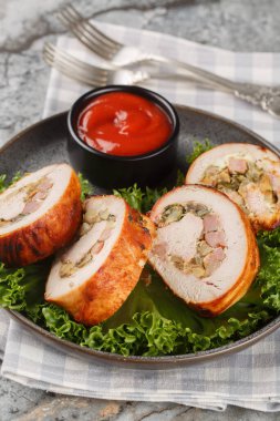 Domuz pastırması, soğan ve mantarla doldurulmuş hindi eti, masada yakın plan domates sosuyla servis edilir. Dikey