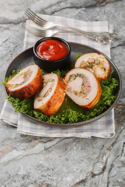 Pastırma, soğan ve mantarlı fırınlanmış hindi göğsü, masada yakın plan domates sosuyla servis ediliyor. Dikey