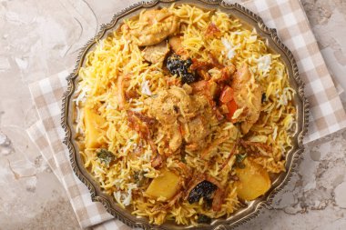 Sindhi Biryani tavuk, basmati pilavı, yoğurt, soğan, yeşil biber, patates ve domatesleri kullanarak masaya yakın çekim yaptı. Yukarıdan yatay üst görünüm