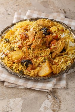Sindhi tavuk biryani baharatlı et, patates, erik, nane, limon ve kişniş karışımı katmanlı pilav masanın üstünde. Dikey
