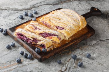 Masanın üzerinde böğürtlenli ve krem peynirli meyveli börek. Yatay