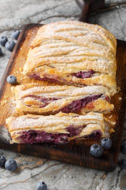 Masadaki tahtaya yakın plan krem peynirli yaban mersinli börek. Dikey