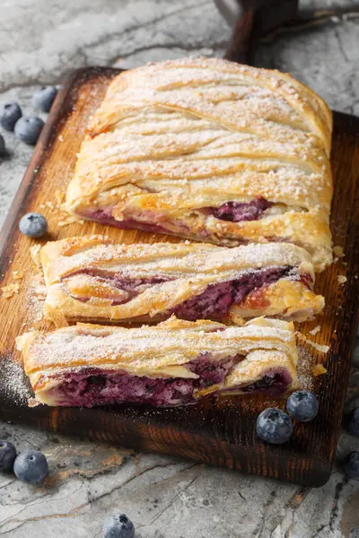 Masadaki tahtaya yakın plan krem peynirli yaban mersinli börek. Dikey