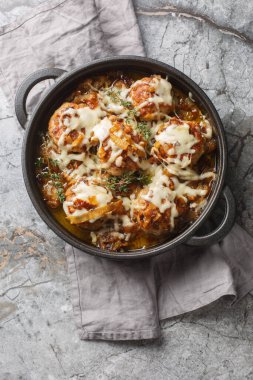 Fransız soğan köfteleri zengin, lezzetli bir soğan sosunun içine yerleştirilir ve üzeri Gruyere ve mozzarella peyniri ile kaplanır. Yukarıdan dikey üst görünüm