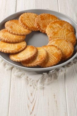 Sable Breton, Bretagne bölgesinden gelen klasik bir tereyağlı kurabiyedir. Masanın üzerindeki tabağa yakın plan. Dikey