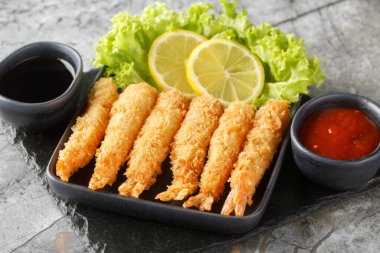 Japon kral karidesleri tempura limon, marul ve iki sosla servis edilir. yatay