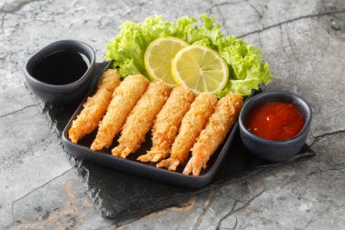 Tempura kızartılmış EBI karidesleri. Baharatlı soslar masaya yakın. Yatay