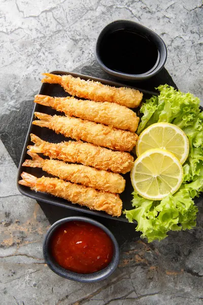 Geleneksel Asya mezeleri çıtır çıtır ekmekli karidesler ve masaya yakın baharatlı soslar. Yukarıdan dikey üst görünüm