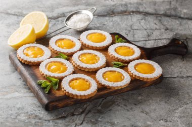 Ev yapımı limonlu kurabiye, çiçek şeklinde, masanın üzerindeki tahta tahtaya yakın plan şeker serpiştirilmiş. Yatay