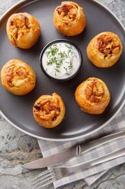 Ukrayna mutfağı Knyshi turtaları, soğan ve patates dolgulu, masada yakın plan ekşi kremayla servis ediliyor. Yukarıdan dikey üst görünüm
