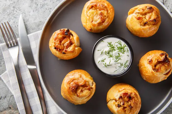 Ukrayna Knysh, masada yakın plan ekşi kremayla servis edilen soğanlı ve patatesli turtalar. Yukarıdan yatay üst görünüm