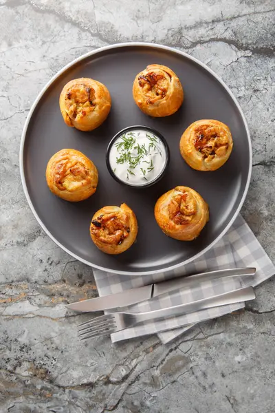 Knish veya knysh, Doğu Avrupa 'nın geleneksel bir yiyeceğidir ve masanın üzerindeki tabakta yakın plan pişirilmiş hamurla kaplıdır. Yukarıdan dikey üst görünüm