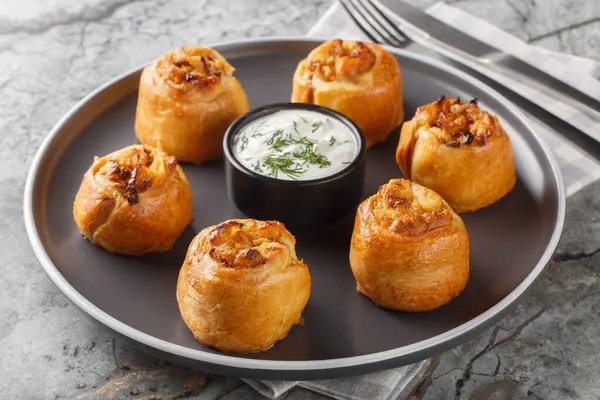 Ukrayna Knysh, masada yakın plan ekşi kremayla servis edilen soğanlı ve patatesli turtalar. Yatay