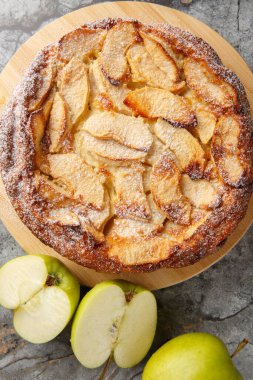 Clafoutis 'in elma versiyonu ünlü bir Fransız tatlısıdır. Masaya yakın plan tarçın ve vanilya ile tatlandırılır. yukarıdan dikey üst görünüm