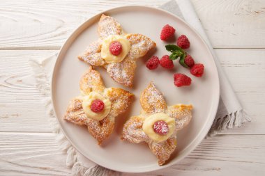Vanilyalı muhallebi ve taze ahudududularla dolu şenlikli poğaça hamur tatlısı. Yukarıdan yatay üst görünüm