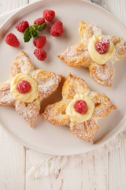 Muhallebi kremalı ve taze ahududu kaplamalı çiçek şeklinde kek. Yukarıdan dikey üst görünüm