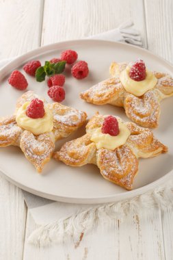 Krema ve taze ahudududulu bir çiçek şeklinde poğaça keki masanın üstünde. Dikey