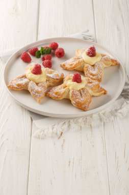 Muhallebi kremalı ve taze ahududu kaplamalı çiçek şeklinde kek. Dikey