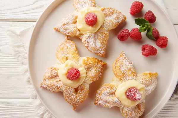 Vanilyalı muhallebi ile nefis yaz puf böreği ve masada taze ahududular. Yukarıdan yatay üst görünüm