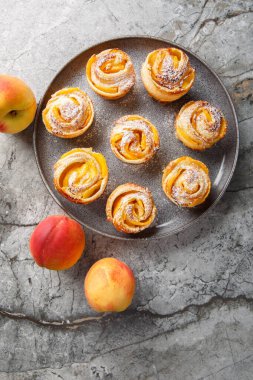 Şeftalili Puf Böreği Gülleri, masadaki tabağa yakın duran en iyi tatlı portresidir. Yukarıdan dikey üst görünüm