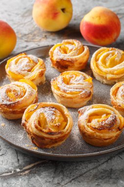 Taze meyveli pudra şekerli şeftali gülleri masaya yakın plan konulacak. Dikey