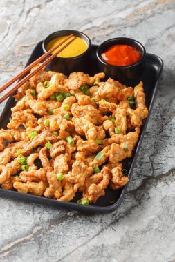 Çıtır domuz Surou veya xiaosurou, yumurta içeren bir hamurla kaplanmış yağlı etten ve daha sonra da masanın üzerindeki tabakta yakın planda kızartılmış etten oluşur. Dikey