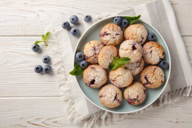 Böğürtlenli kurabiyeler ve üzerine pudra şekeri serpiştirilmiş masanda yakın plan bir tabakta. Yukarıdan yatay üst görünüm