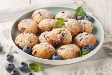 Böğürtlenli kurabiyeler ve üzerine pudra şekeri serpiştirilmiş masanda yakın plan bir tabakta. yatay