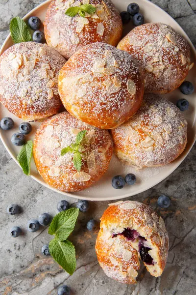 Masanın üzerindeki tabakta mercimeği fırına vermiş taze bademli çörekler. Yukarıdan dikey üst görünüm
