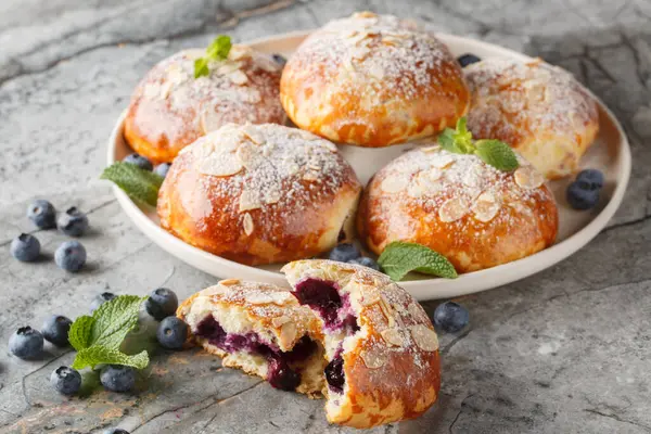 Masadaki tabakta yaban mersinli ve badem yapraklı ev yapımı Fransız çörekleri. Yatay