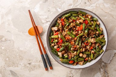 Yeşil fasulye, dolmalık biber, sarımsak, zencefil ve soya sosuyla kızartılmış domuz kıyması. Yukarıdan yatay üst görünüm