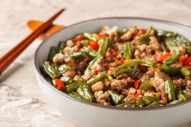 Yeşil fasulyeli çıtır domuz kızartması, sarımsak ve dolmalık biber masadaki kaseye yakın çekim. Yatay